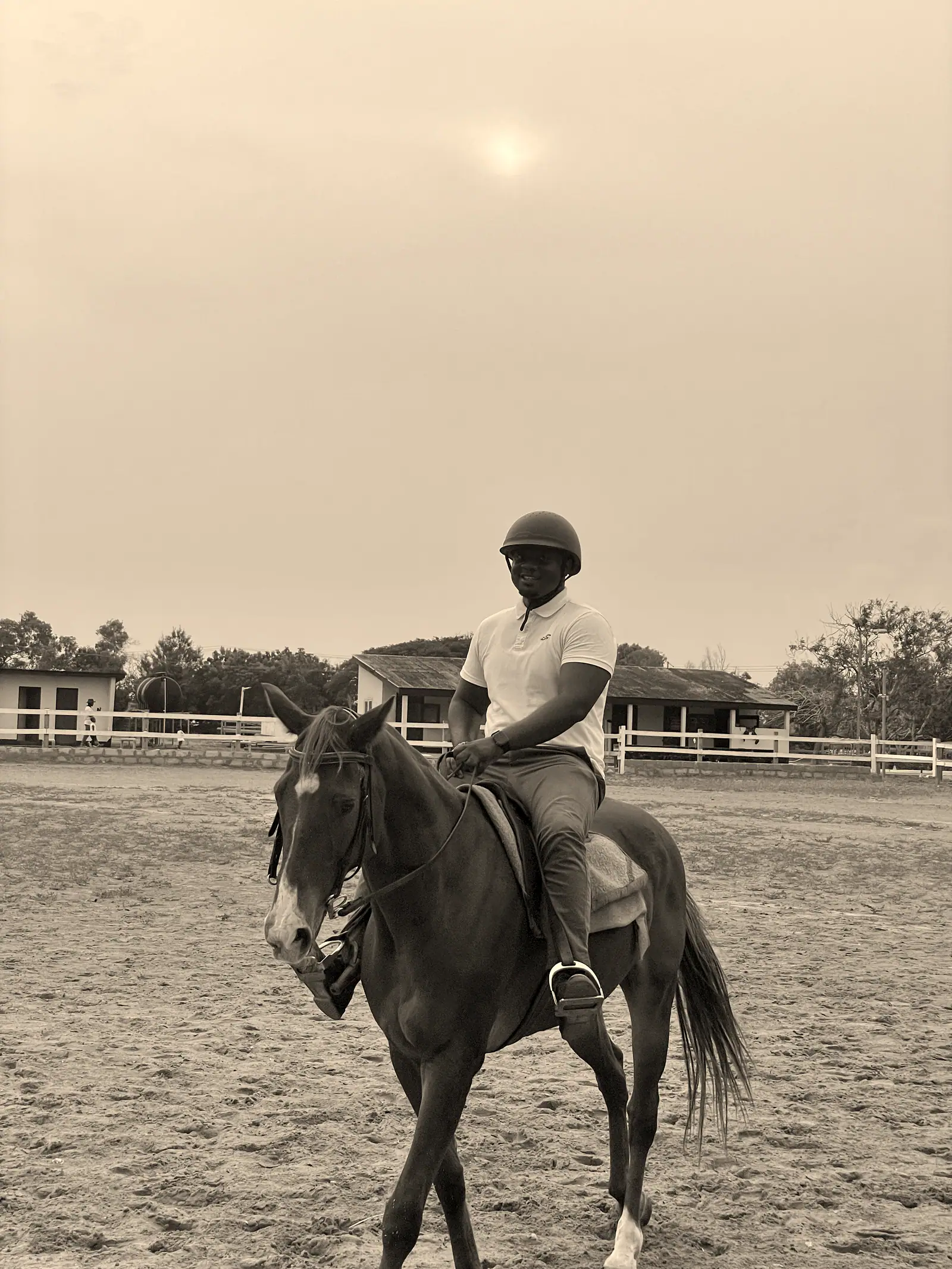 David wearing a riding helmet and sitting on a chestnut horse.